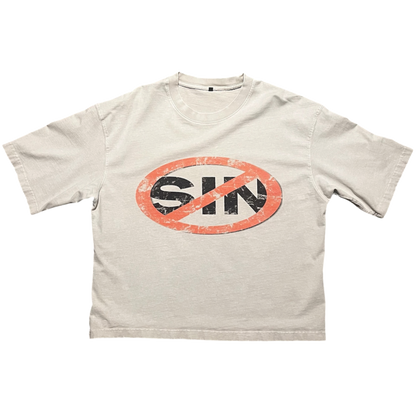 A light beige crewneck t-shirt featuring a distressed graphic on the chest of the word 'SIN' in black inside an orange oval, crossed out with a red prohibition symbol.